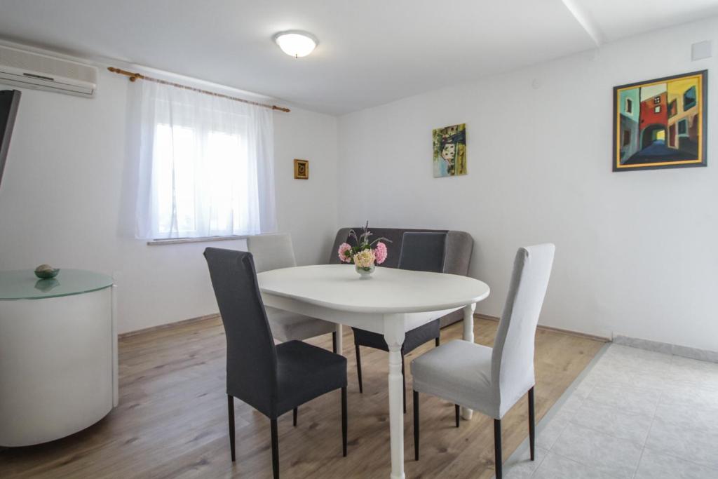 een witte eetkamer met een witte tafel en stoelen bij Apartment Tosca with Parking in Rovinj