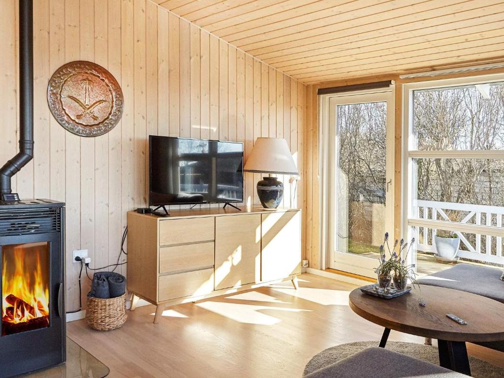 un salon avec une télévision et une cheminée dans l'établissement Holiday home Slagelse XLII, à Slagelse