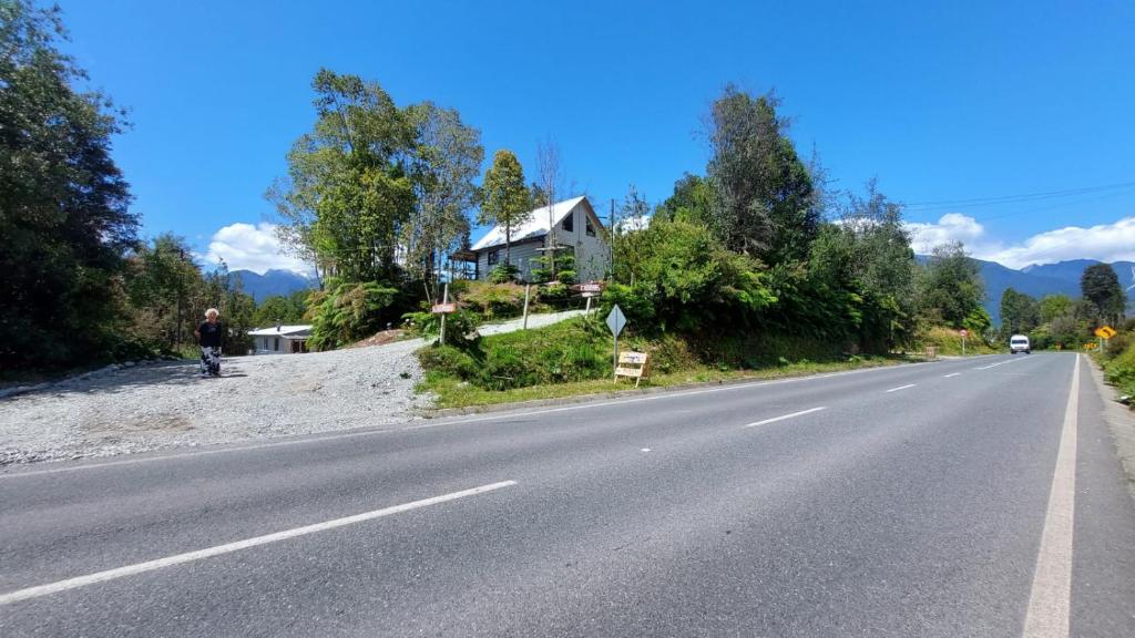 um homem está de pé na beira de uma estrada em Cabañas & Habitaciones Del Alto em Hornopiren