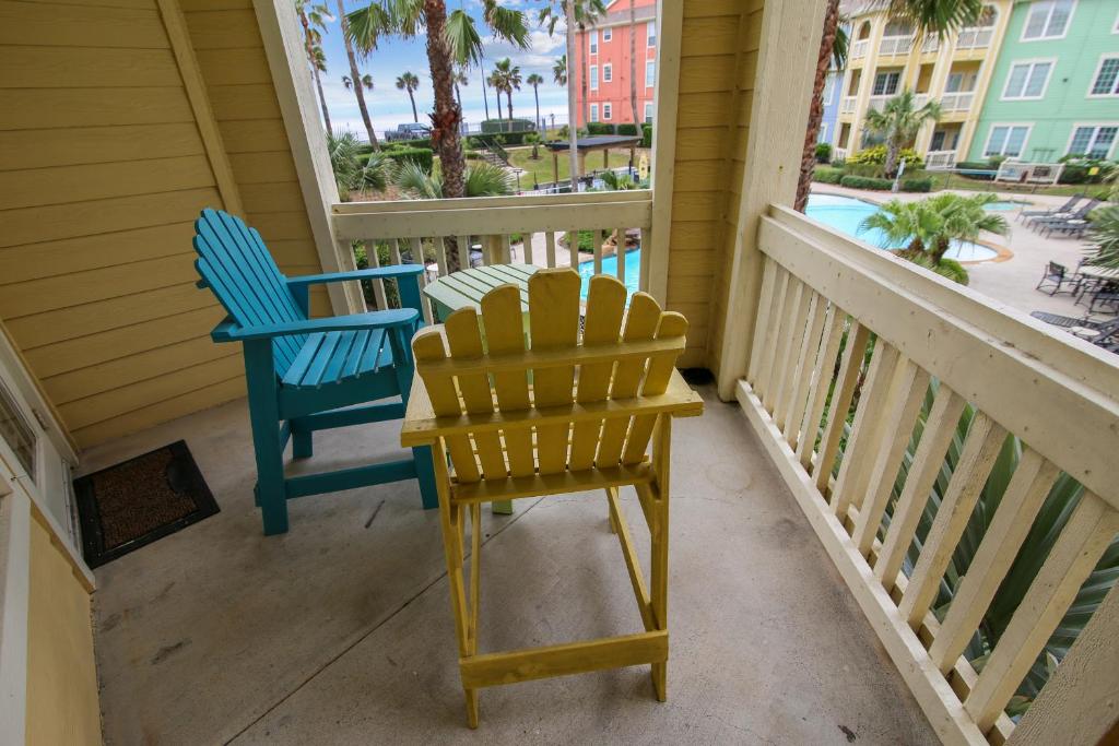 two chairs and a table on a porch with a view at Dawn 722-Poolside Paradise in Galveston