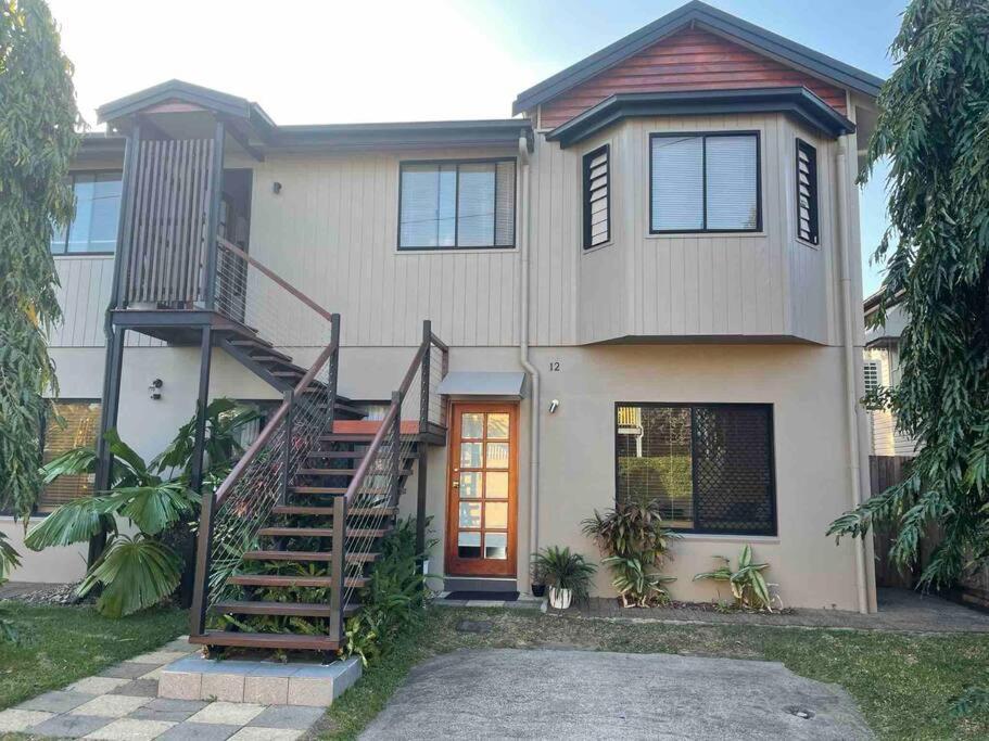 a house with a staircase in front of it at City centre, tropical home, minutes walk to shops. in Cairns