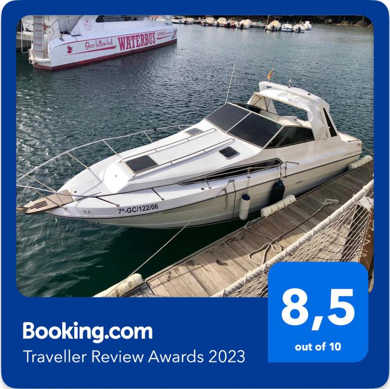 a white boat is docked at a dock at Barco TUAREG in Puerto Calero