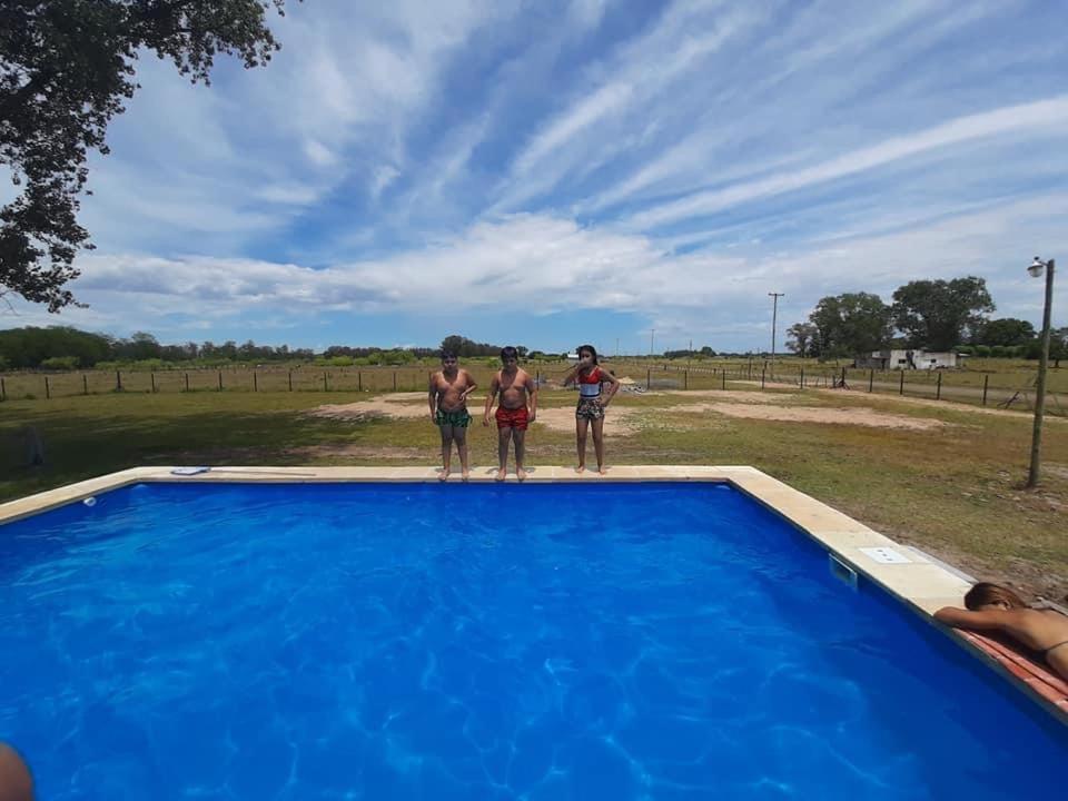 Tre uomini in piedi sul bordo di una piscina blu di Camino al Sol Domselaar wifi a Domselaar