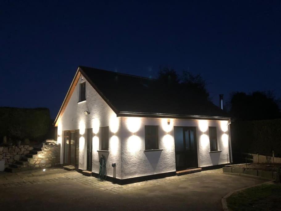 a white building with lights on it at night at Country Cottage close to the city. in Newry