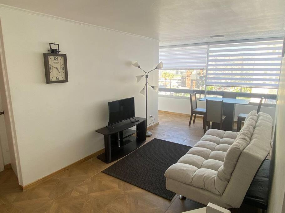 a living room with a couch and a tv and a table at Apartamento en Viña del Mar in Viña del Mar