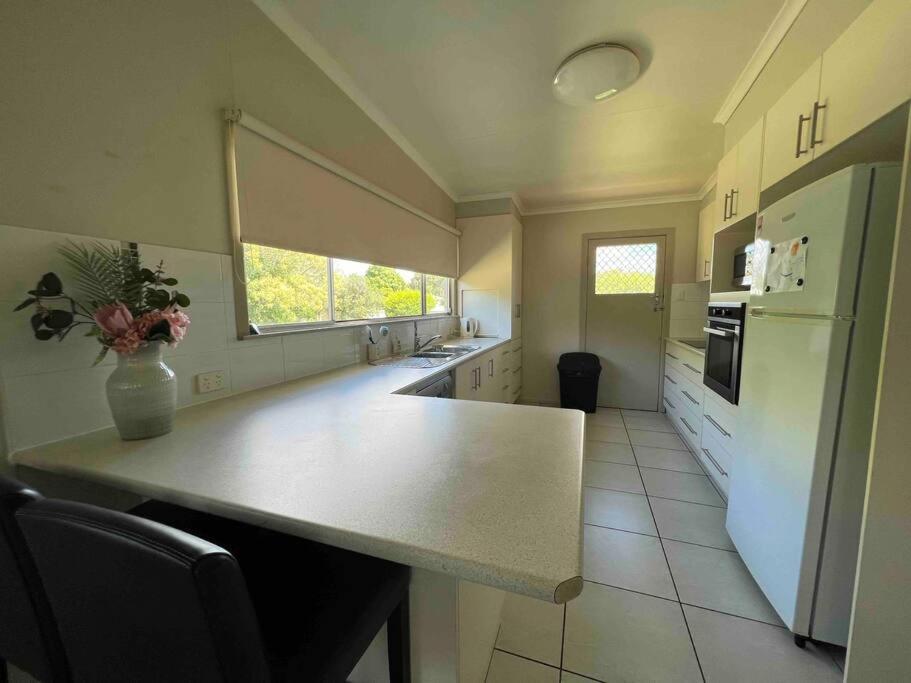 een keuken met een aanrecht en een witte koelkast bij 3 bedroom house in great location in Goondiwindi