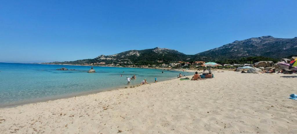 a group of people on a beach near the water at Casa Mar, studio 4P, vue mer, Sant'Ambroggio, Lumio in Lumio