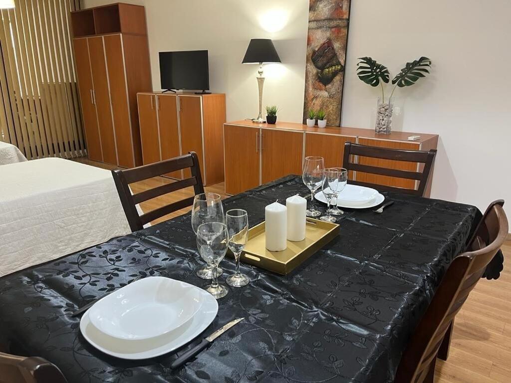 uma mesa de jantar com uma toalha de mesa preta, pratos brancos e velas em Apart Archipiélago em Rosário