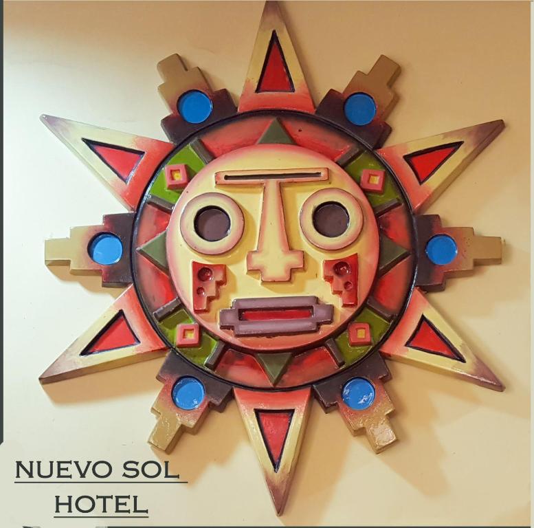 a wooden sun clock hanging on a wall at Hotel Nuevo Sol in La Paz