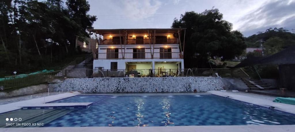 una casa con piscina frente a una casa en El Guadual Casa Campestre, en Ibagué