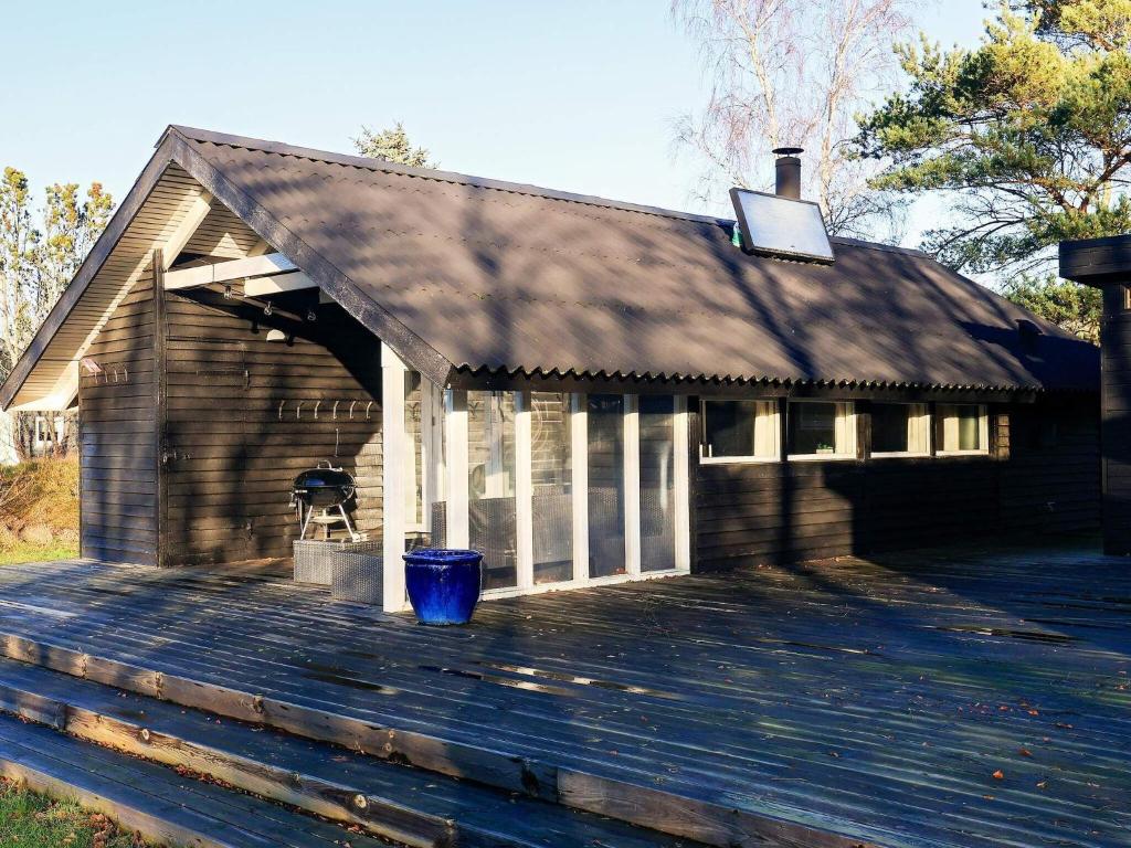 Ålbækにある4 person holiday home in lb kのゴミ箱付きのデッキのある建物