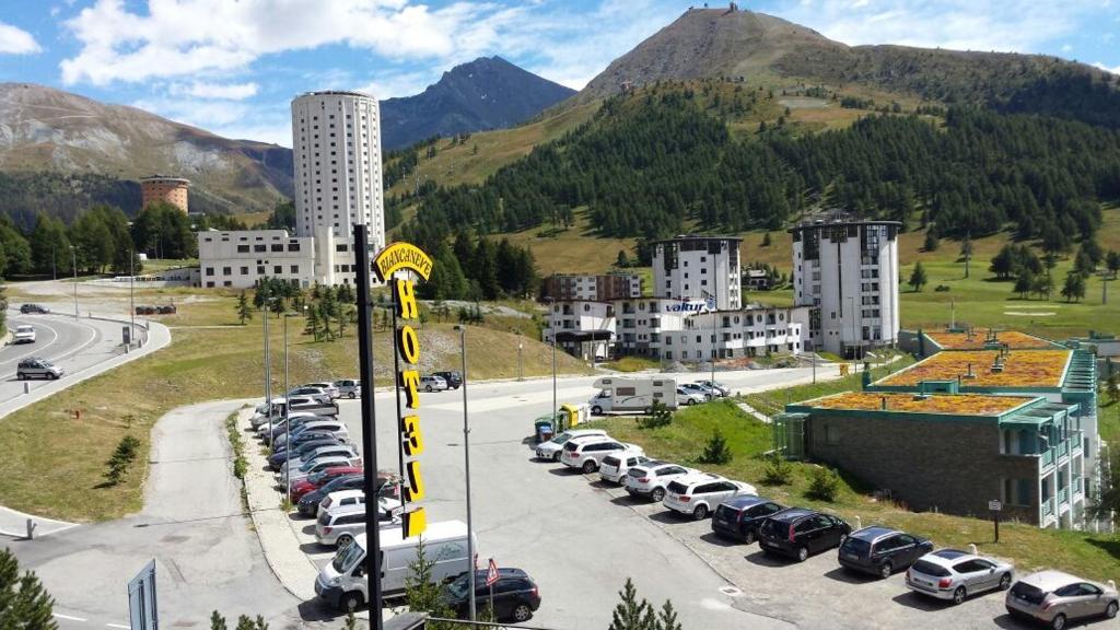 a parking lot with a bunch of parked cars at Hotel Biancaneve in Sestriere