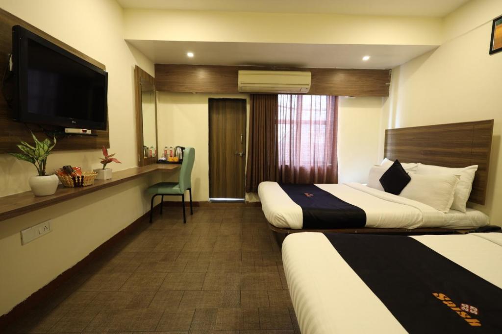 Postel nebo postele na pokoji v ubytování Saish Hotel Shirdi