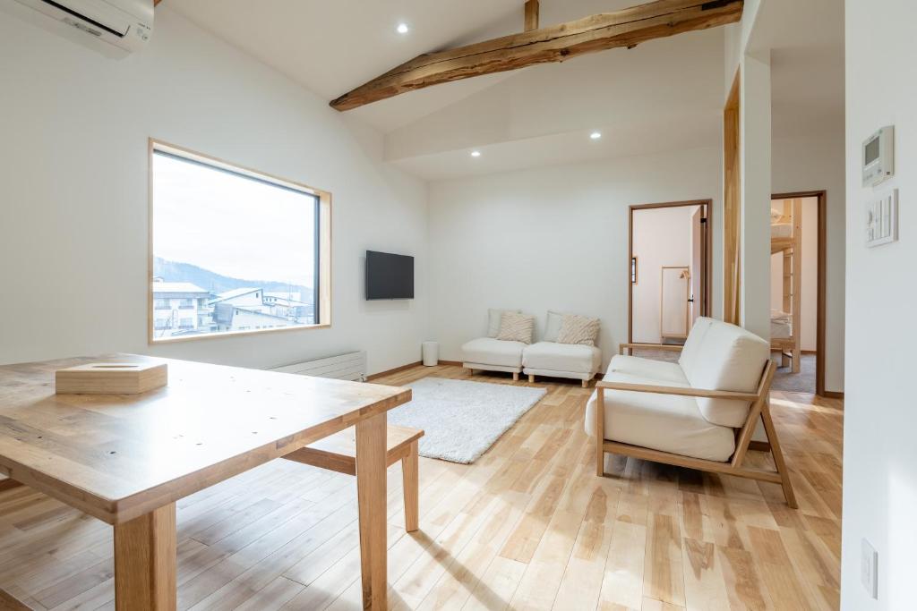 a living room with a wooden table and chairs at Dennojo in Nozawa Onsen
