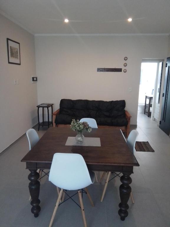 een woonkamer met een houten tafel en witte stoelen bij cel2245508464 Céntrico in Dolores