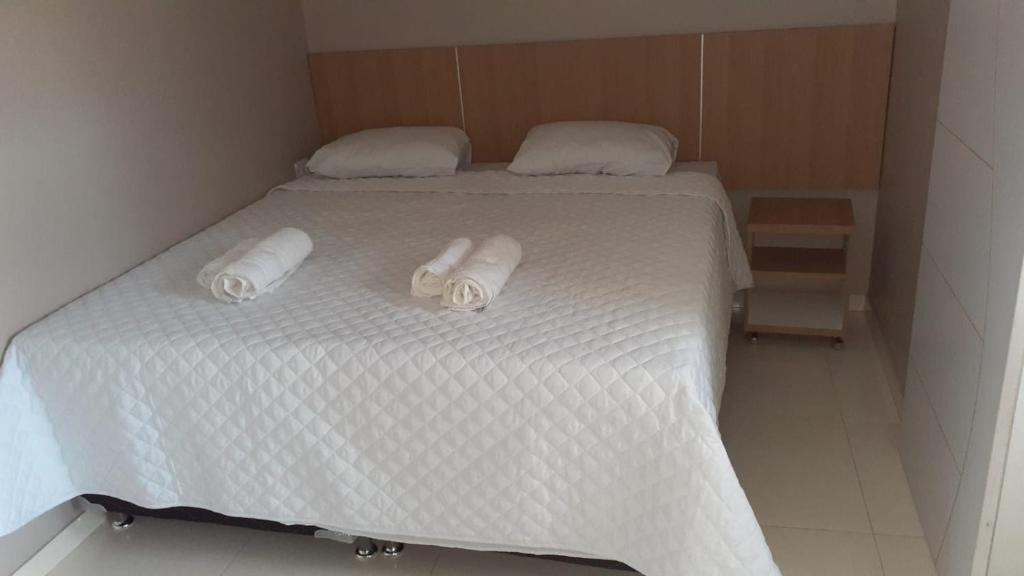 - un lit blanc avec 2 serviettes dans l'établissement Pousada Recanto Gentil, à Triunfo