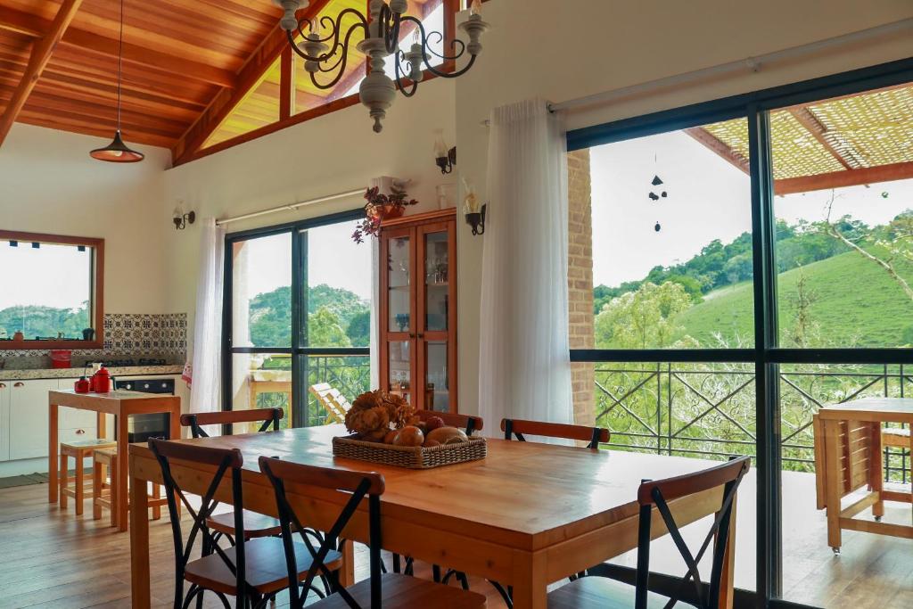 comedor con mesa de madera y sillas en Linda vista para as montanhas a 5 min da cidade, en Santo Antônio do Pinhal
