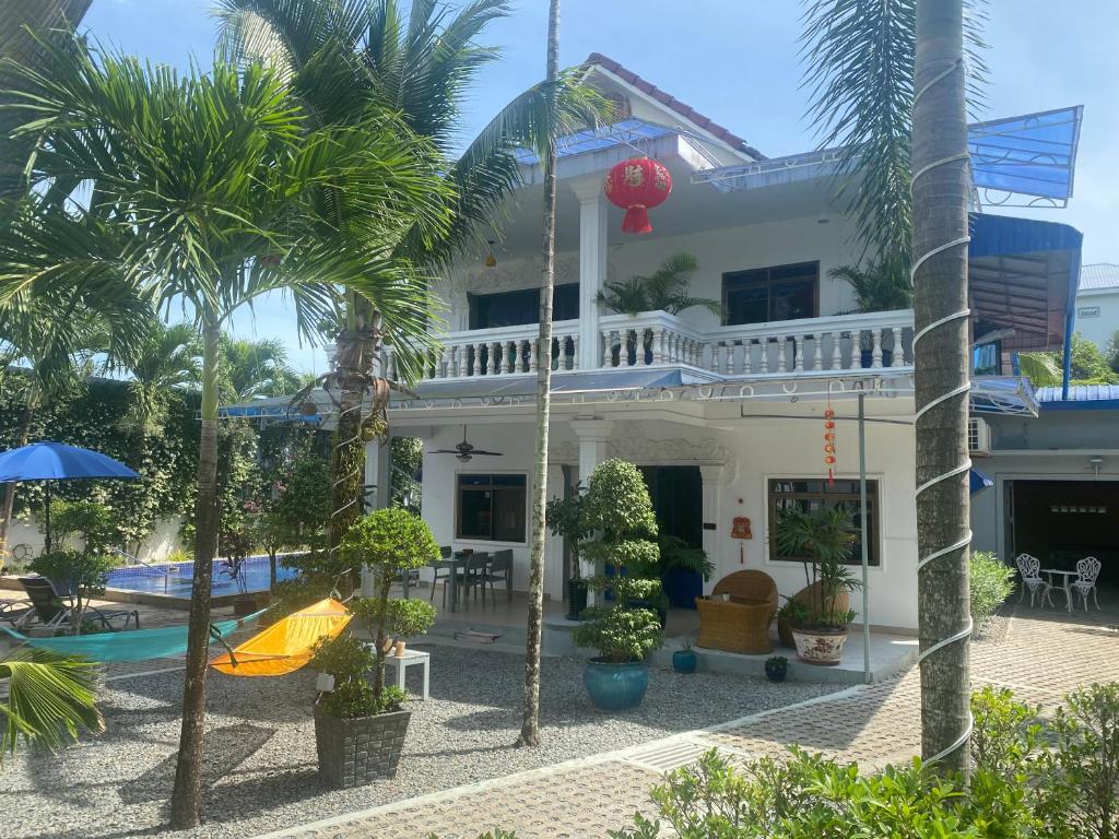 a house with a swimming pool and palm trees at Villa Blue Lagoon in Sihanoukville