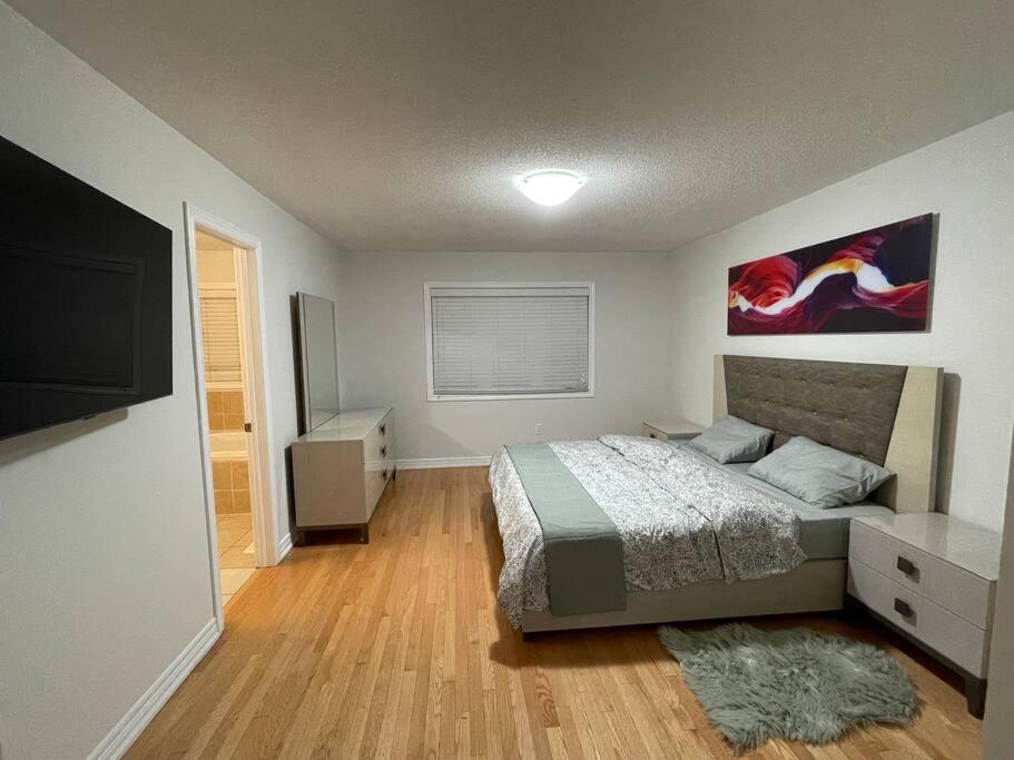 a bedroom with a bed and a flat screen tv at Luxury 4-Bedrooms Home… in Brampton