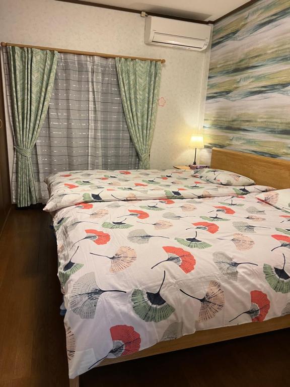 ein Schlafzimmer mit einem Bett mit einer bunten Bettdecke in der Unterkunft 舟荘 in Osaka