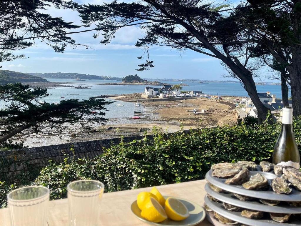 een tafel met borden en uitzicht op het strand bij Premium holiday home in top location with sea view, Plougasnou in Plougasnou