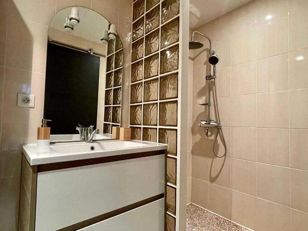a bathroom with a sink and a shower with a mirror at Premium holiday home in top location with sea view, Plougasnou in Plougasnou