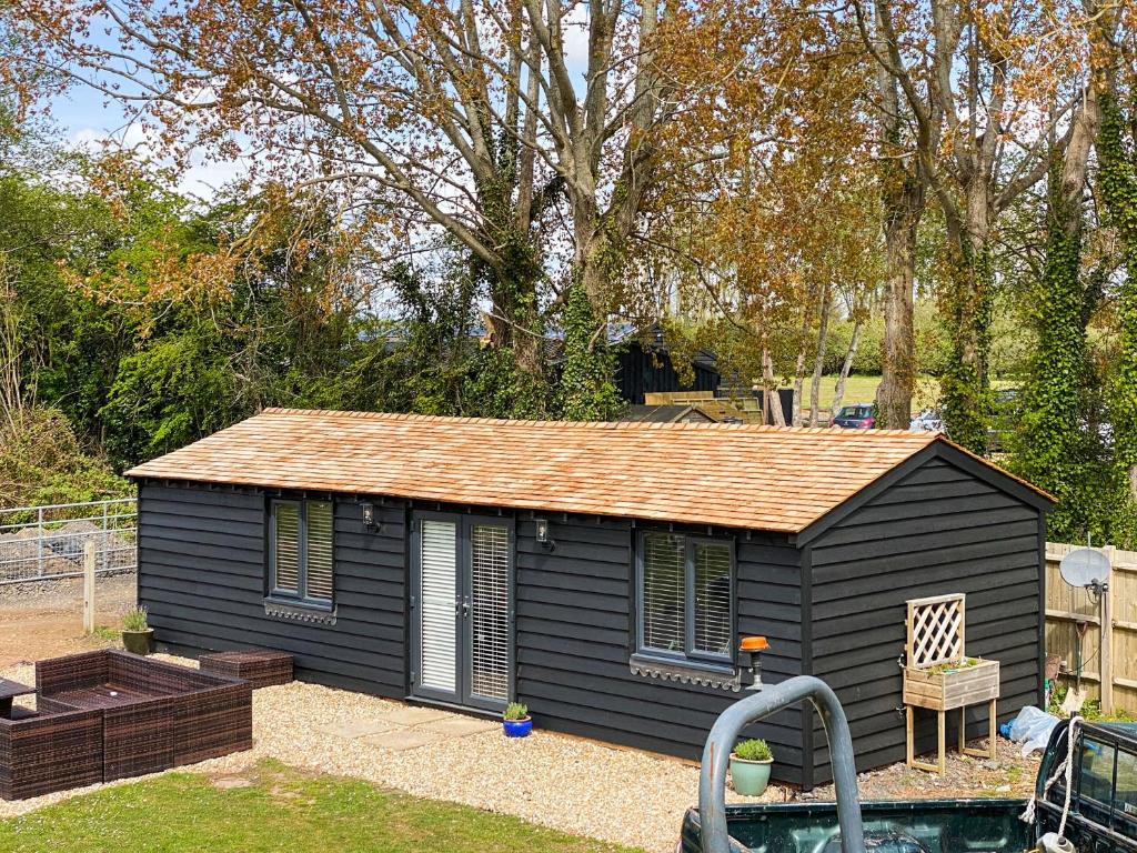 a small black shed sitting in a yard at The Cabin in Southbourne