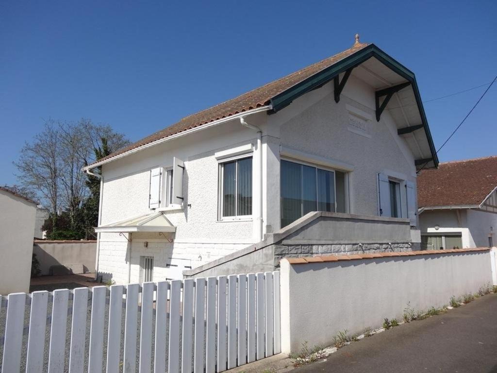 une maison blanche avec une clôture devant dans l'établissement Maison Centre Village, Proche Plage, 3 Chambres, Jardin Clos, Idéale Sans Voiture - FR-1-476-156, à La Faute-sur-Mer