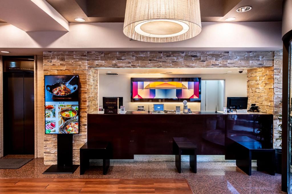 a bar in a lobby with a stone wall at Hotel Sun White in Osaka