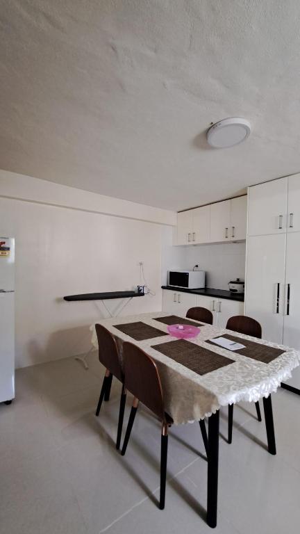 a kitchen with a table and chairs in a room at Mead Road Homestay Tours &Transfers Deluxe Flat 1 Bedroom in Suva