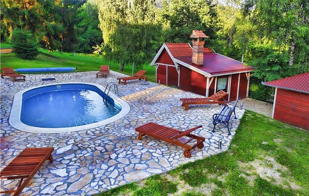 um quintal com uma piscina com bancos e um edifício em Stunning Home In Novo Zvecevo With Sauna em Novo Zvecevo