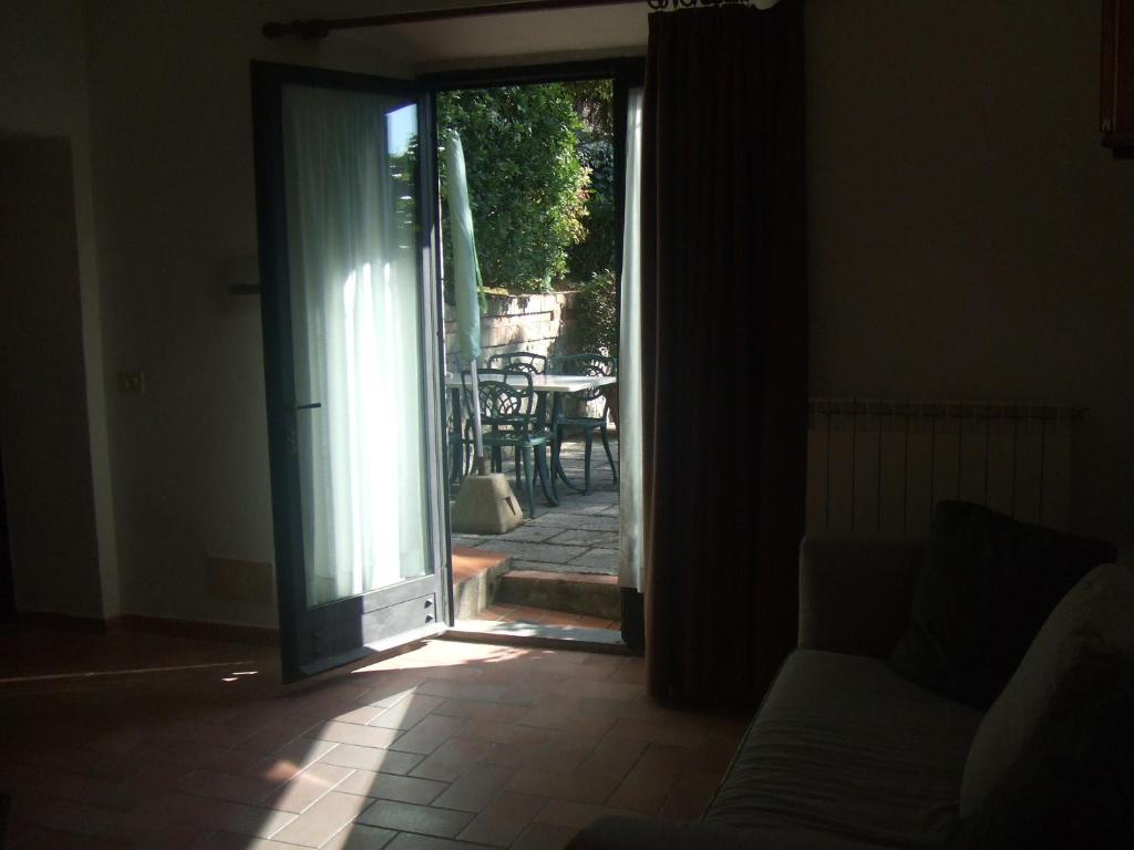 Otwarte drzwi na patio ze stołem i krzesłami w obiekcie Appartamento La Palma w mieście San Gimignano