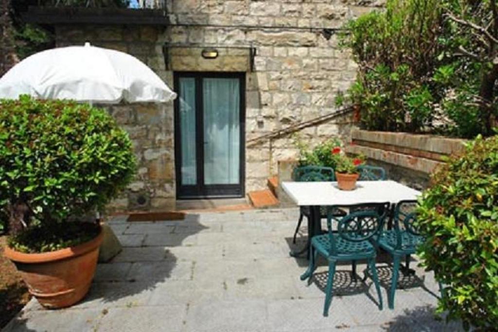 patio ze stołem, krzesłami i parasolem w obiekcie Appartamento La Palma w mieście San Gimignano
