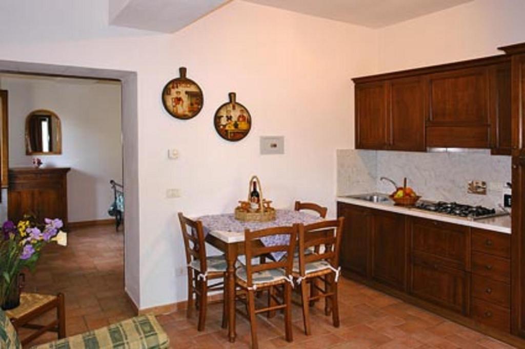 kuchnia ze stołem i krzesłami w kuchni w obiekcie Appartamento La Palma w mieście San Gimignano