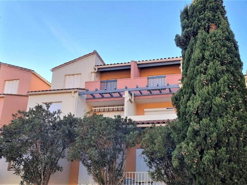 a pink building with trees in front of it at Appartement Cerbère, 2 pièces, 4 personnes - FR-1-309-361 in Cerbère