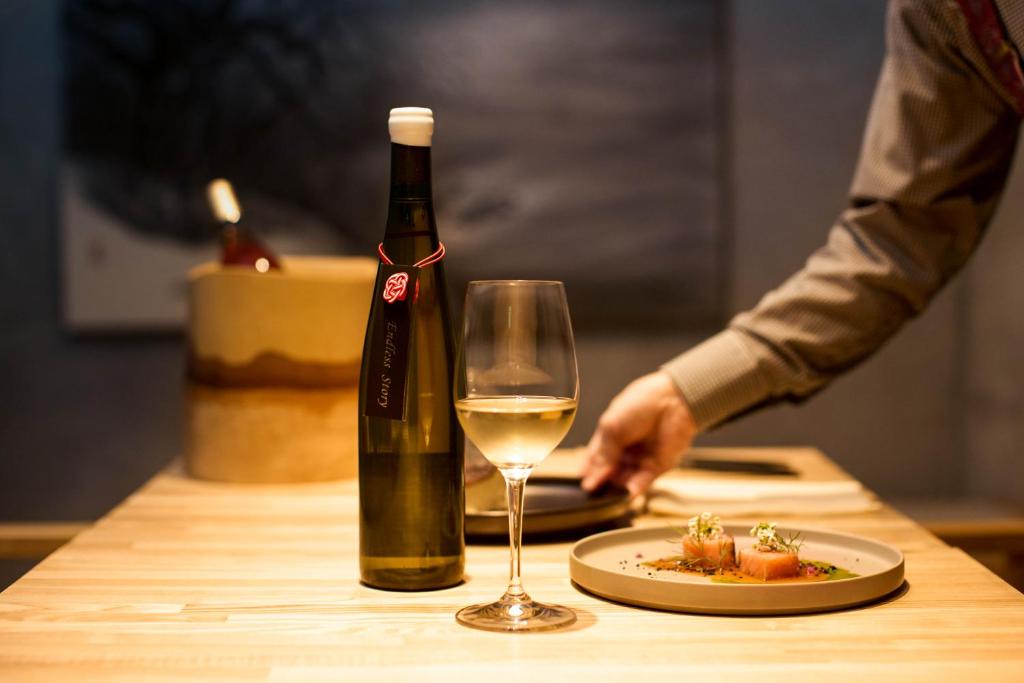 a bottle of wine and a plate of food on a table at Yoichi LOOP in Kurokawamachi