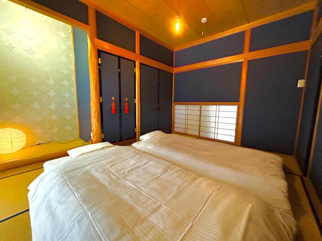 duże łóżko w pokoju z oknem w obiekcie 旅籠屋ゆいまーる w mieście Mameda-shimmachi