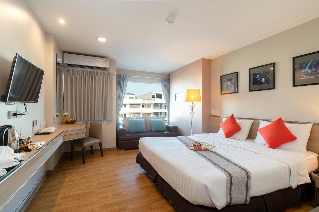 a hotel room with a large bed and a desk at Bangkok Loft Inn in Bangkok