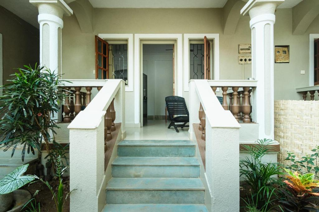 a house with a staircase leading to the front porch at Jolene's Ashvem in Mandrem