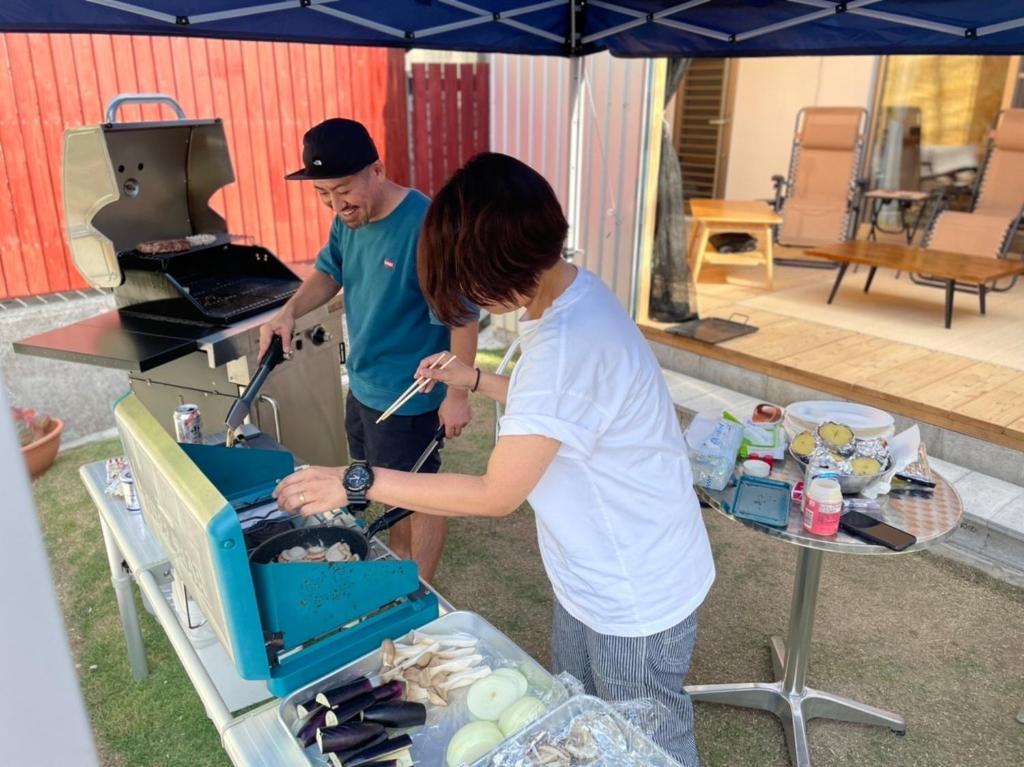 a man and a woman standing next to a grill at Resort Villa umiyui - Vacation STAY 48991v in Inbu