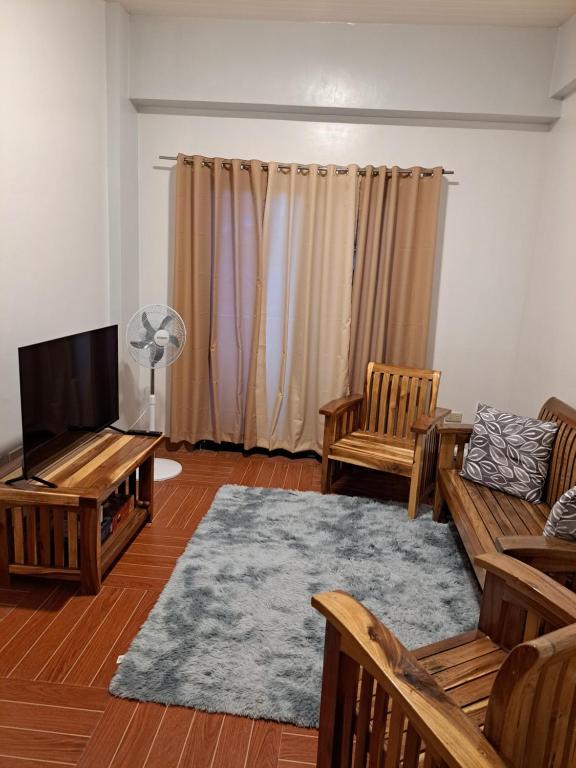 uma sala de estar com um sofá e uma televisão em C1 em Baguio