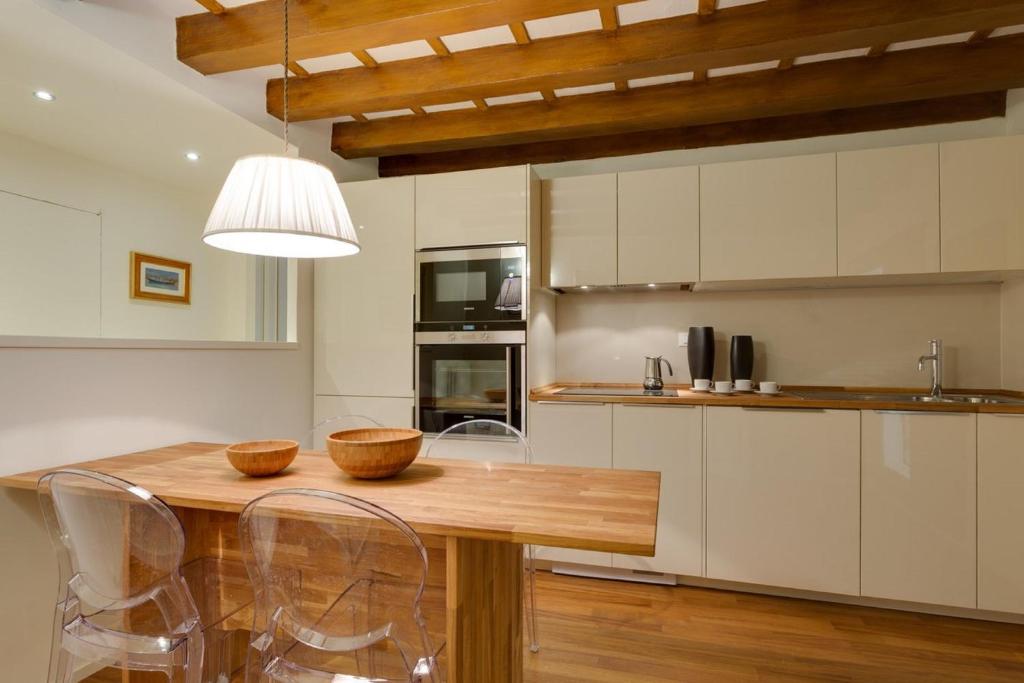 a kitchen with a wooden table and some chairs at Apartments Florence - Vigna Nuova Alberti in Florence