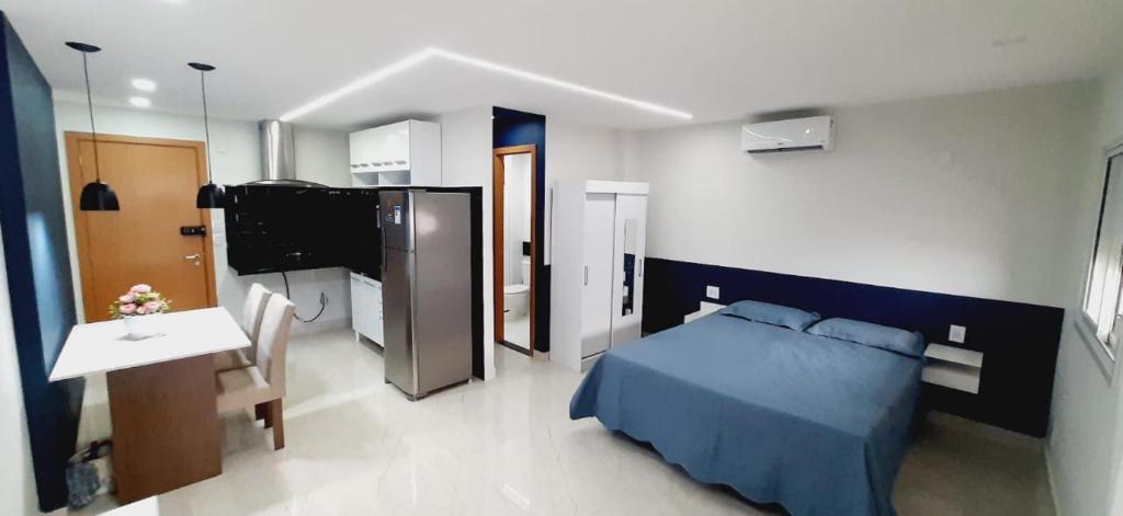 1 dormitorio con 1 cama azul y TV en FLAT 22º andar totalmente mobiliado lazer completo, en Guarulhos