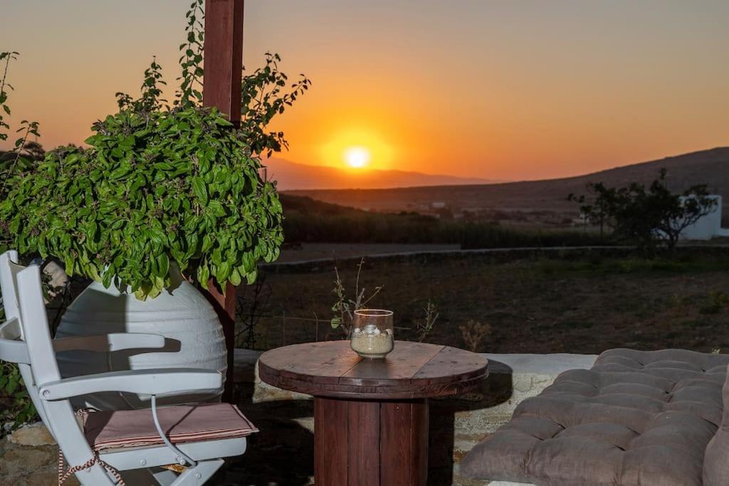 a table and a chair with a sunset in the background at Anamnisis in Kanakiri