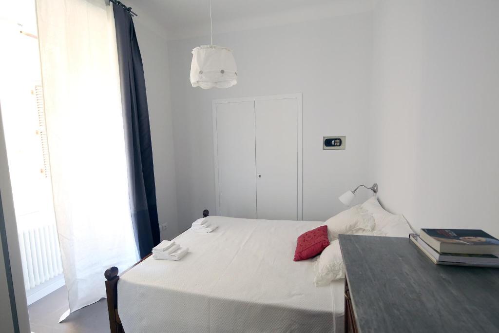 een kleine witte slaapkamer met een bed en een tafel bij Nido Degli Angeli in Rome