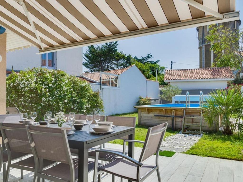 patio ze stołem i krzesłami oraz basenem w obiekcie Maison Capbreton, 4 pièces, 8 personnes - FR-1-413-87 w mieście Capbreton