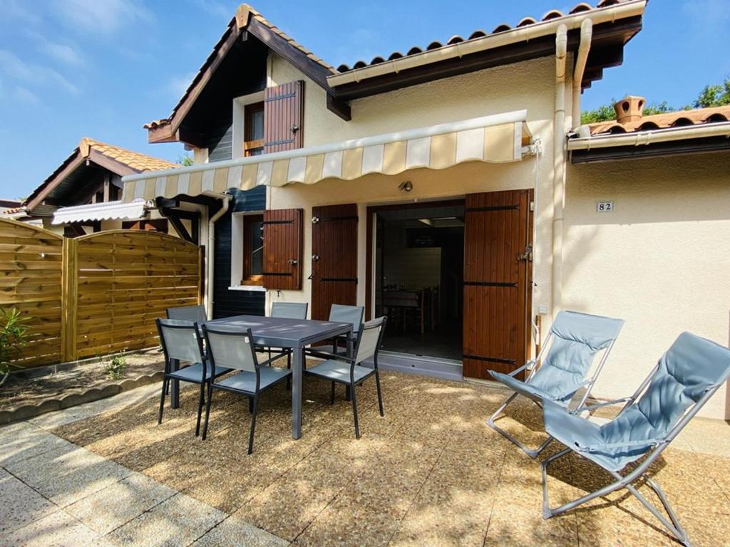 a patio with a table and chairs in front of a house at Villa Capbreton, 3 pièces, 4 personnes - FR-1-413-174 in Capbreton