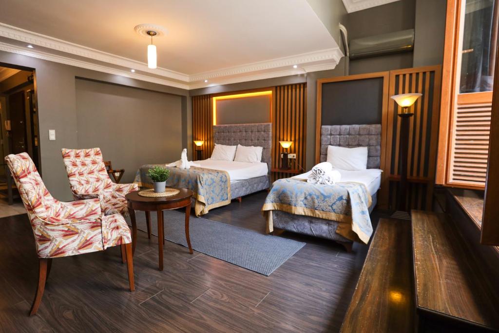 een hotelkamer met 2 bedden en een stoel bij Cumbali Luxury Boutique Hotel in Istanbul