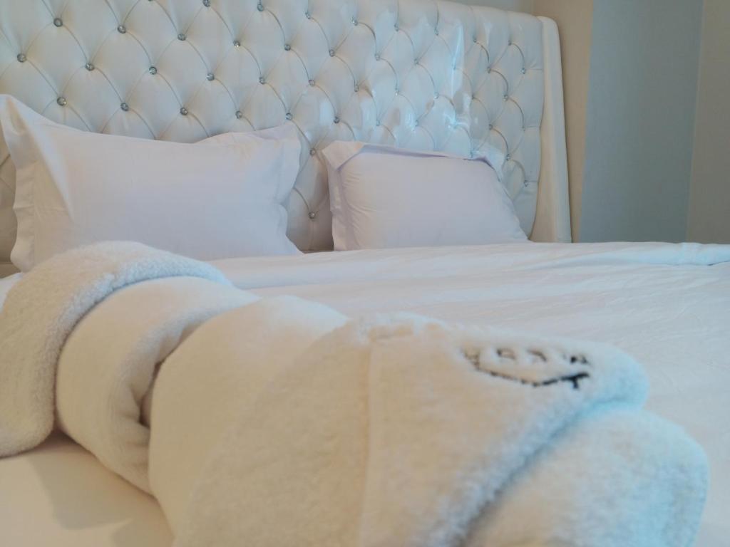 Una cama blanca con una manta. en Minimalist Cozy Apartment by MESA, en Nagoya