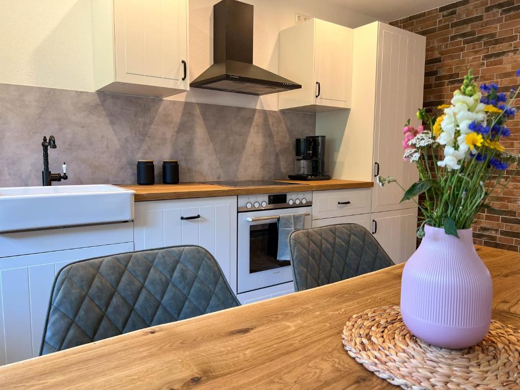 a kitchen with a table with a vase of flowers on it at Ferienwohnung Holiswald in Oppenau